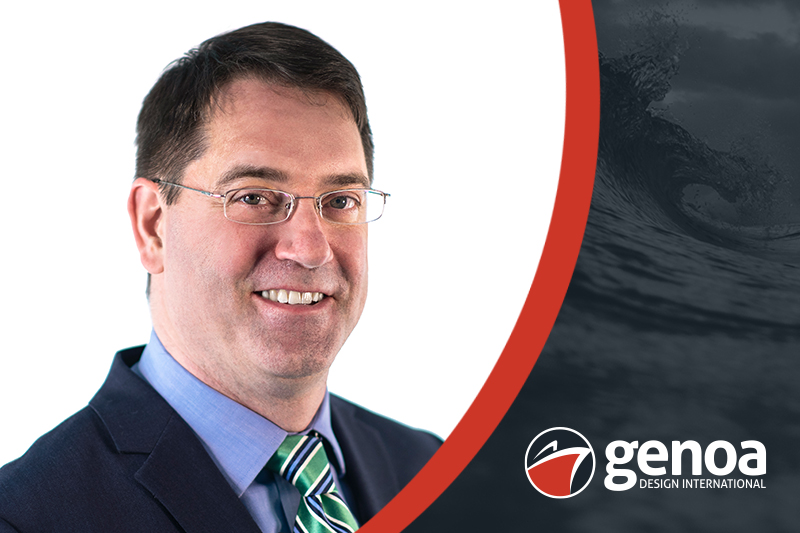 Professional man in navy jacket with a blue shirt and green, blue and white striped tie smiling into the camera, with dark waves in the background and Genoa Design International logo in the forefront.